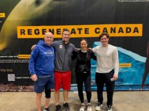 Four people stand in gym clothes, smiling in front of a backdrop that says "Regenerate Canada."